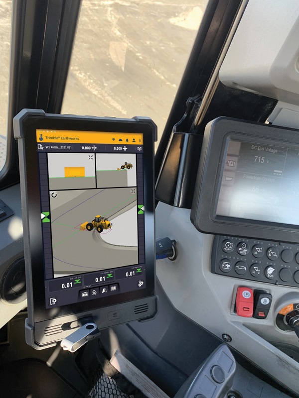 Interior de la cabina de una pala de ruedas con el sistema 3D Trimble Earthworks en funcionamiento, mostrando una pantalla con gráficos detallados del terreno y la maquinaria en tiempo real para una operación precisa y eficiente.