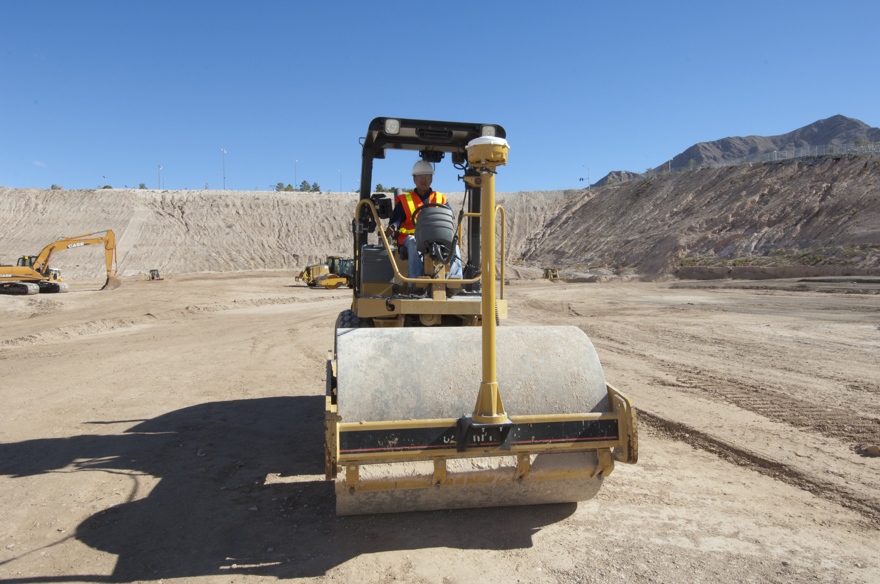 Operador a manobrar um compactador de solo num sítio de construção e a otimizar a compactação graças ao Sistema 3D Trimble Earthworks