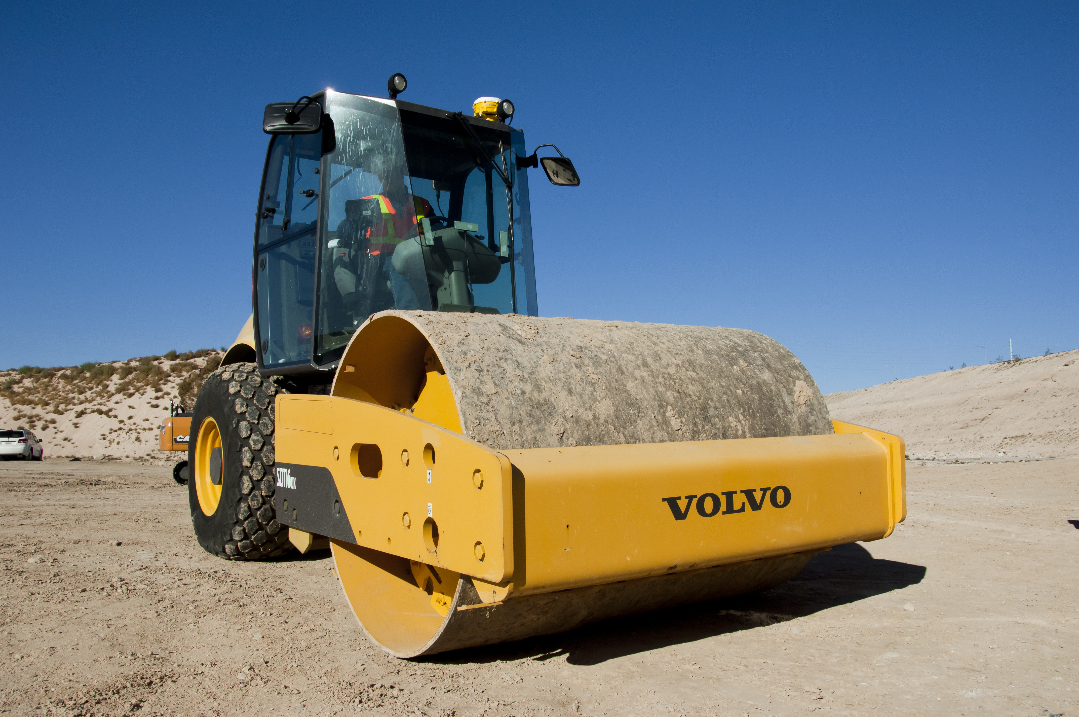 Compactador Volvo amarelo com rolo liso num ambiente de construção, utilizando o sistema Trimble Earthworks 3D para uma compressão eficiente e precisa