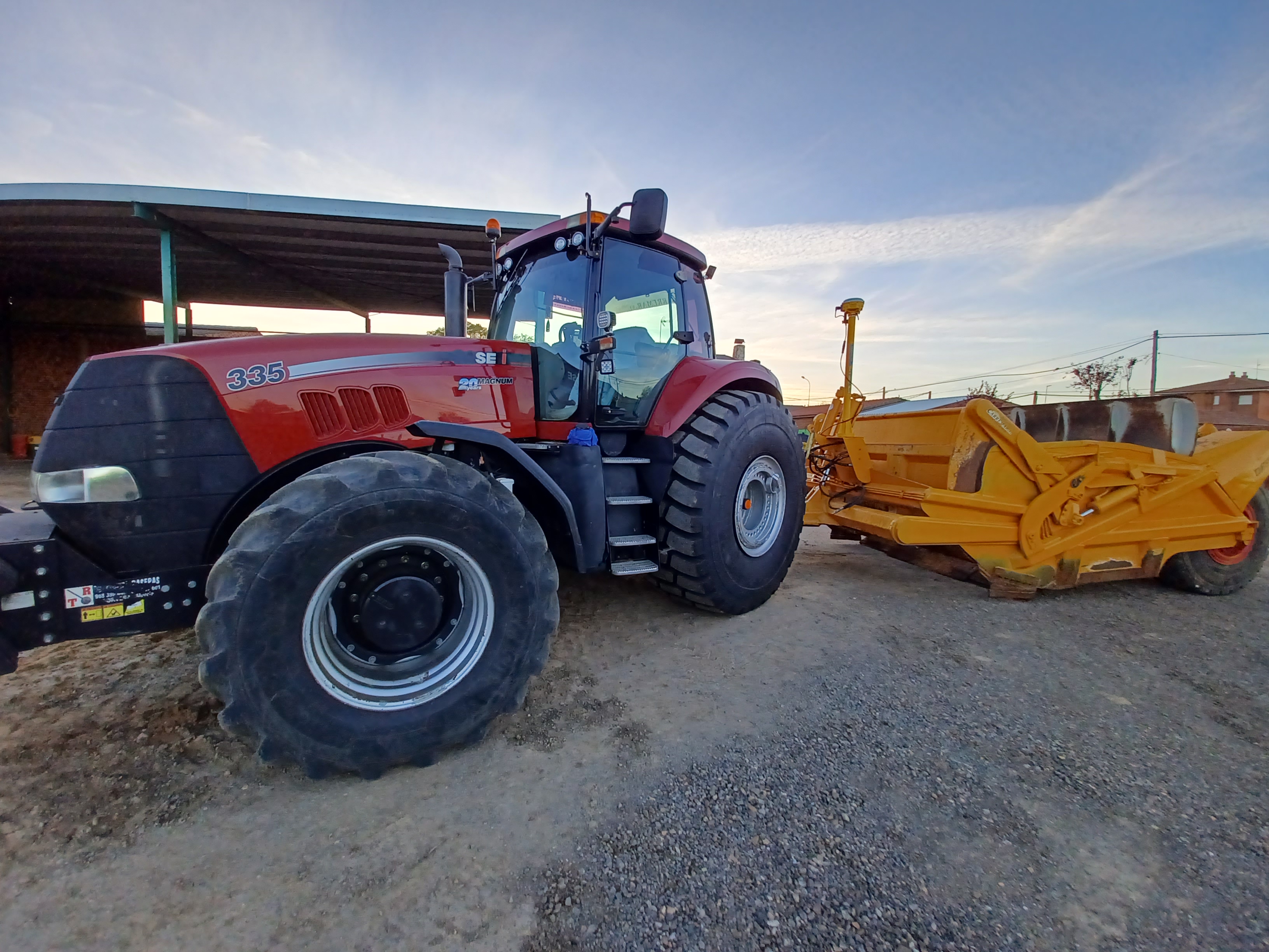 Trator agrícola vermelho equipado com o sistema 3D Trimble Earthworks, demonstrando tecnologia avançada para construção de precisão