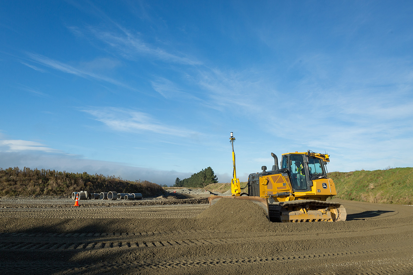 Bulldozer Caterpillar con Sistema de guiado 3D y Bulldozer John Deere con Sistema de guiado 3D trabajan en terreno de construcción. La tecnología avanzada de guiado por GPS es visible en los mástiles y receptores montados sobre las cabinas