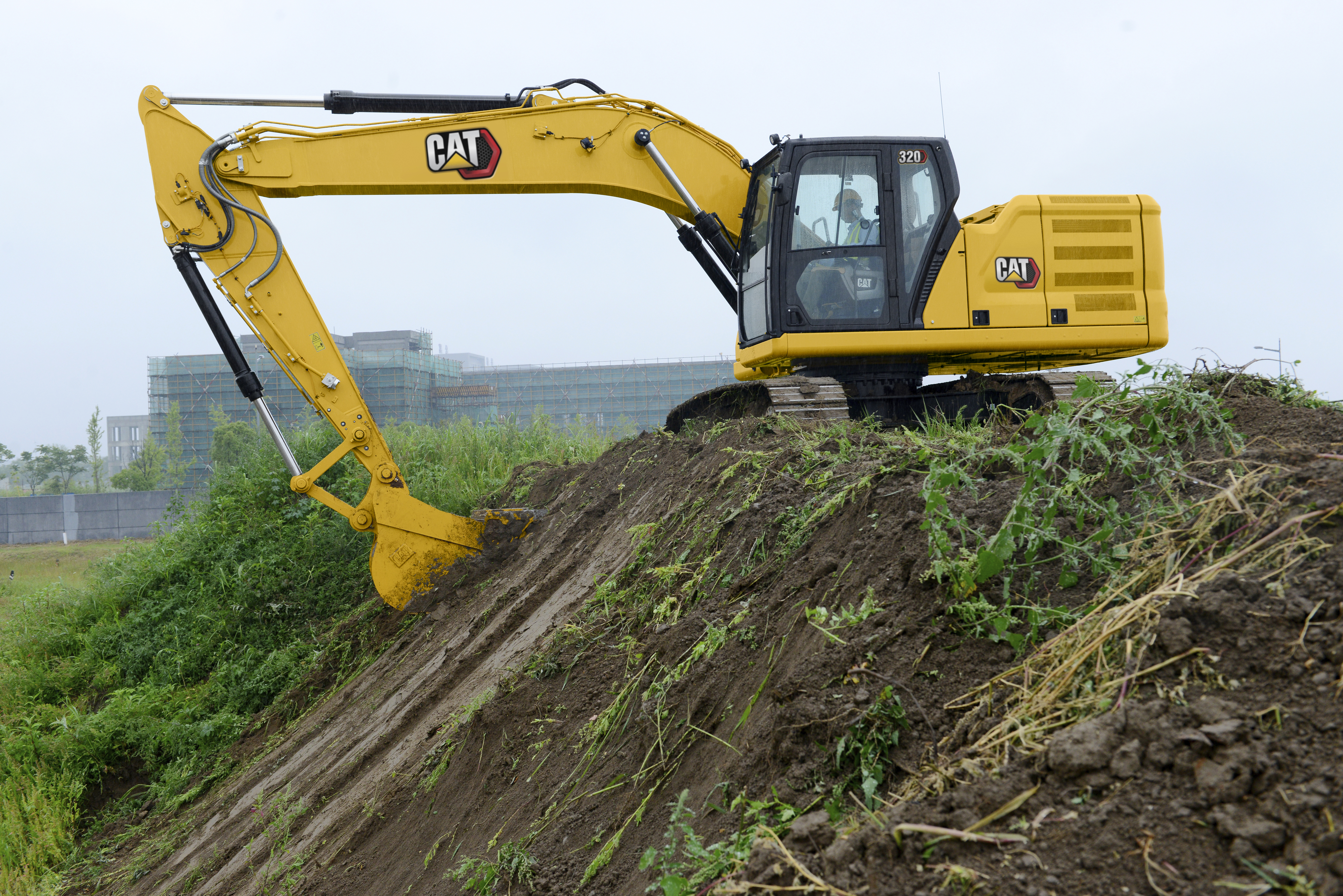 xcavadora CAT amarilla equipada con sistema de guiado 3D Trimble Earthworks trabajando en terreno inclinado, demostrando precisión y eficiencia en proyectos de construcción
