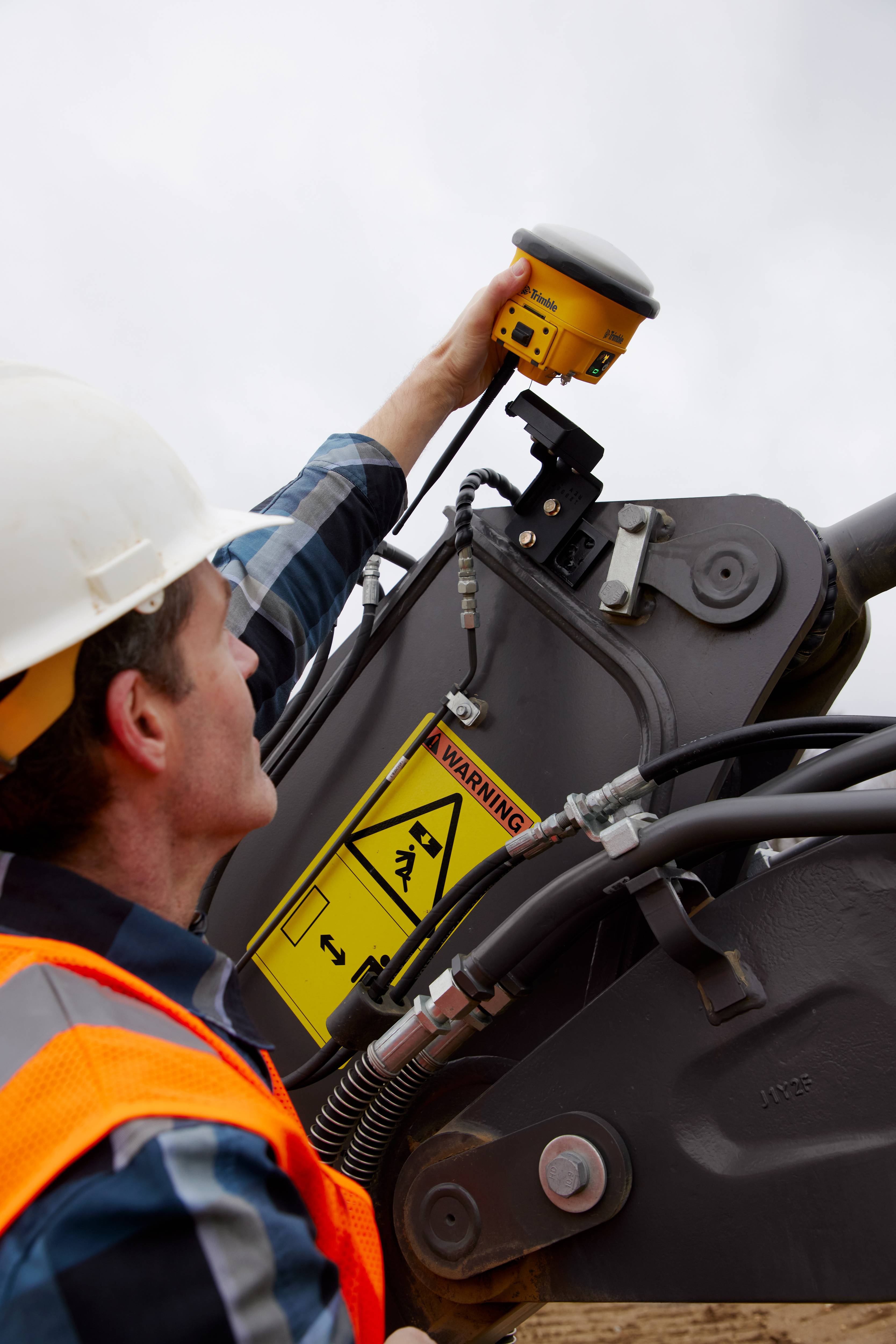 Operador a colocar o Trimble Siteworks Machine Guidance Module numa escavadora