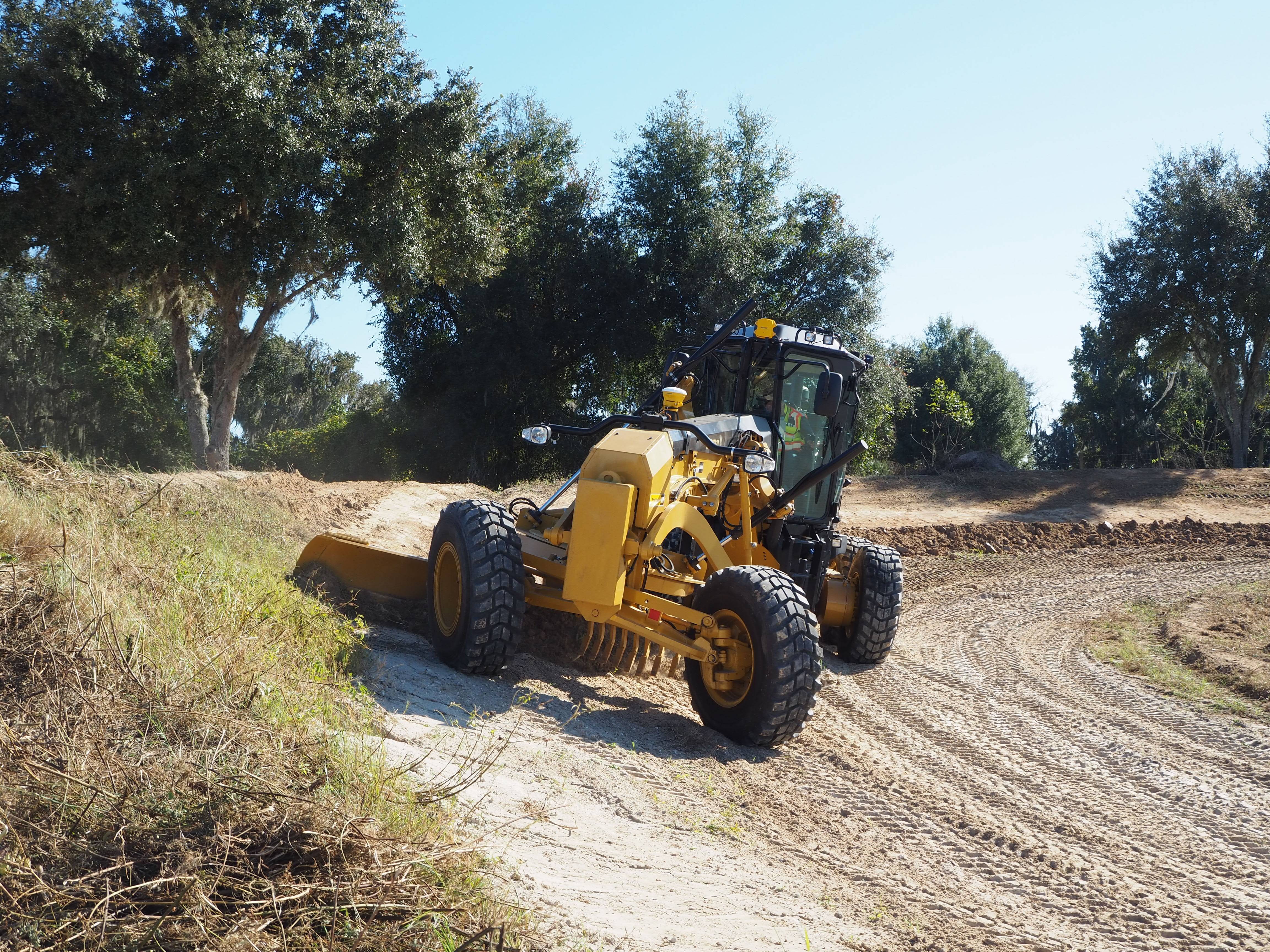 Motoniveladora Caterpillar equipada com o sistema Trimble Earthworks a trabalhar num terreno irregular. O sistema 3D de controlo de equipamentos garante precisão e eficiência na nivelação