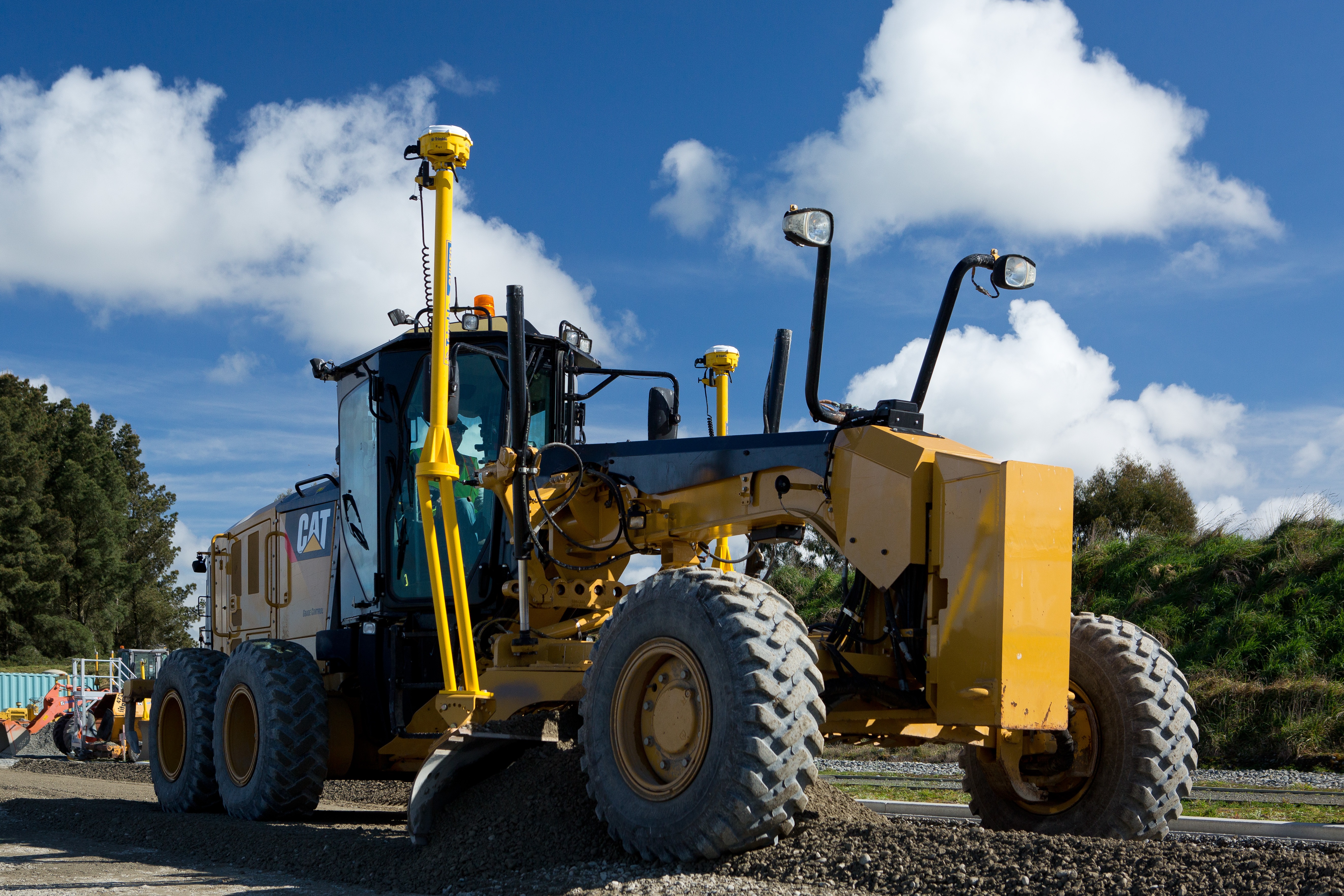 Motoniveladora CAT equipada con el sistema Trimble Earthworks 3D para control de maquinaria. Los sensores inerciales y demás componentes del sistema de guiado resaltan en la máquina