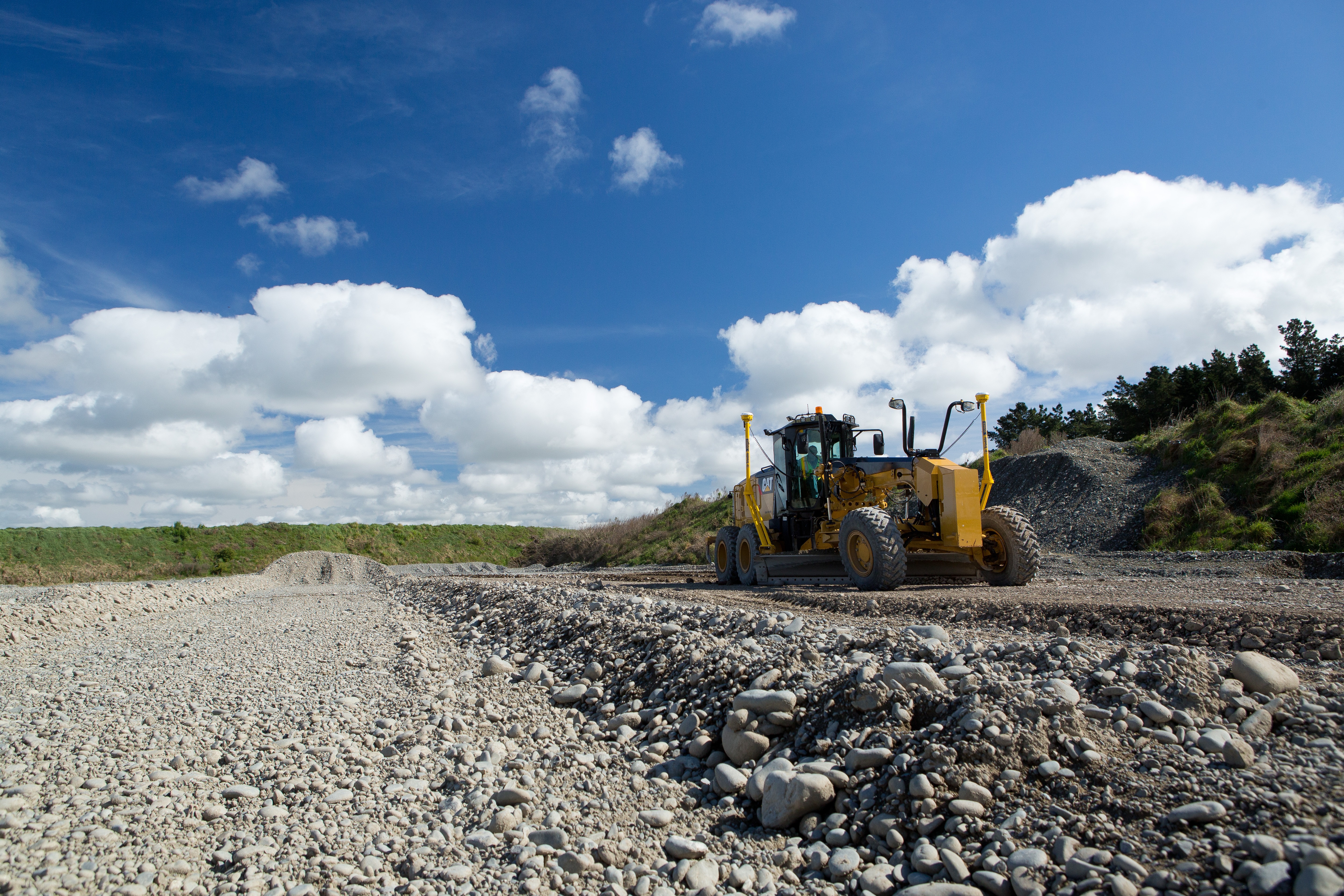 Sistema 3D Trimble Earthworks instalado en una Motoniveladora en acción sobre terreno de grava